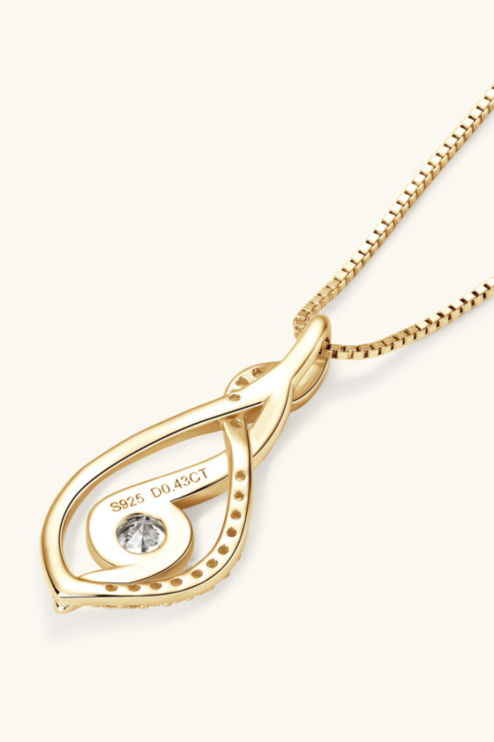 Gold pendant necklace with a diamond on a white background