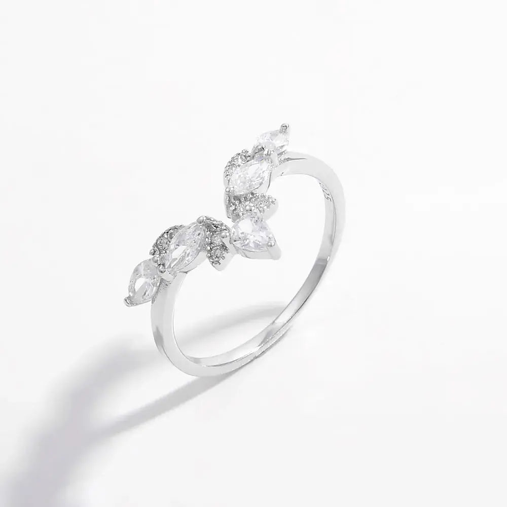Silver ring with leaf-shaped gemstones on a white background