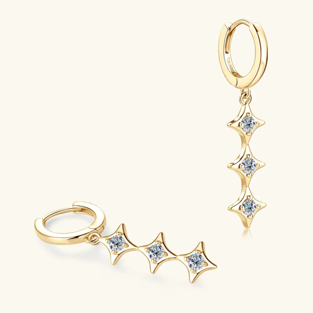 Gold hoop earrings with star-shaped gemstones on a white background