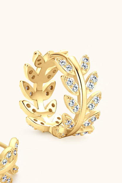 Gold earring with leaf design and clear stones on a white background