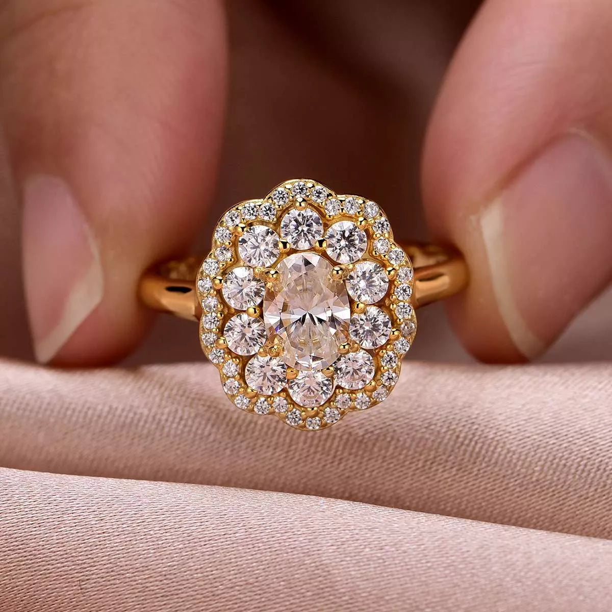 Gold ring with a large diamond and smaller diamonds on a beige fabric background