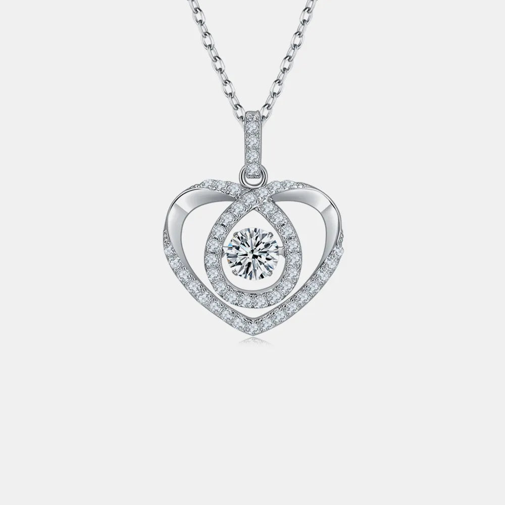 Heart-shaped silver pendant with a central round gemstone on a light gray background