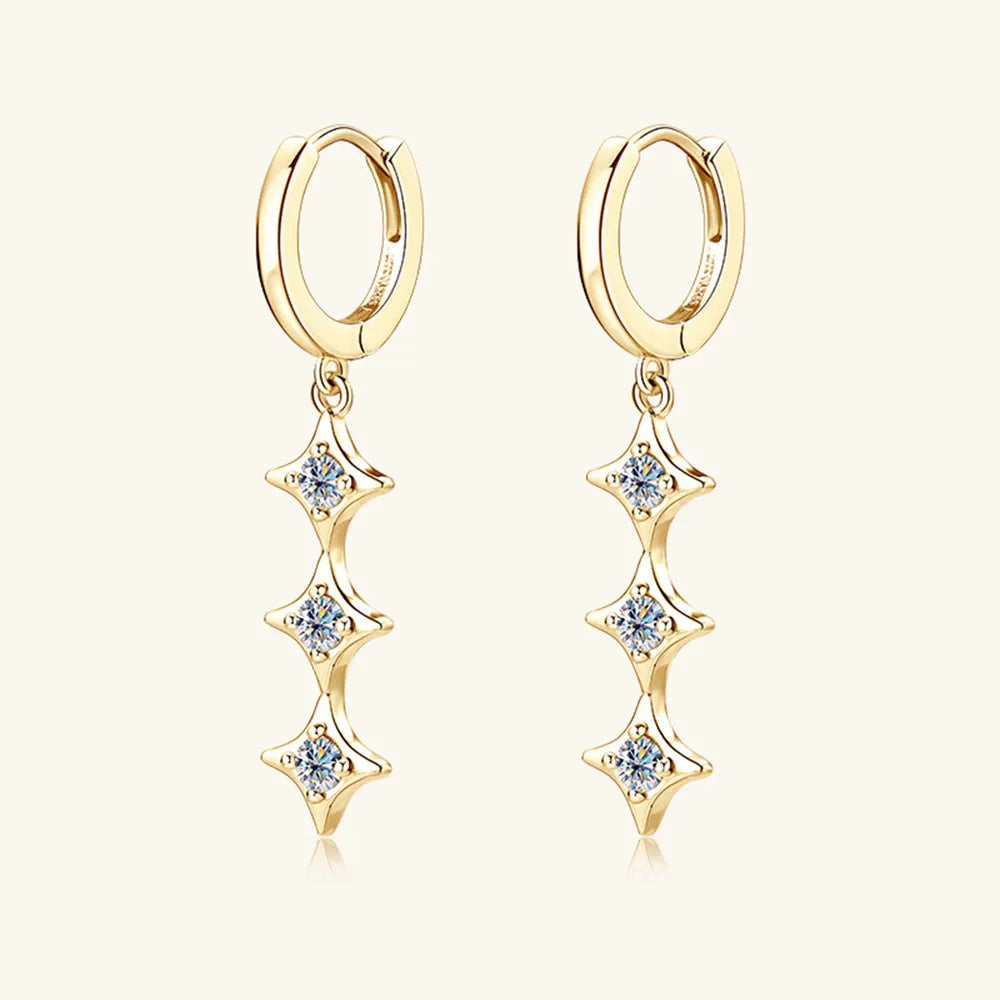Gold hoop earrings with star-shaped diamond drops on a white background