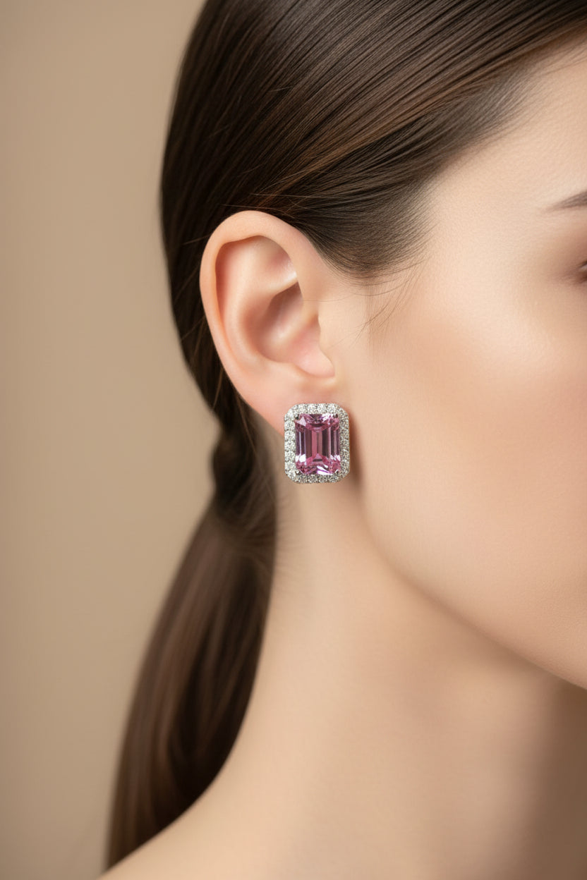Pink gemstone earring worn by a model on a beige background
