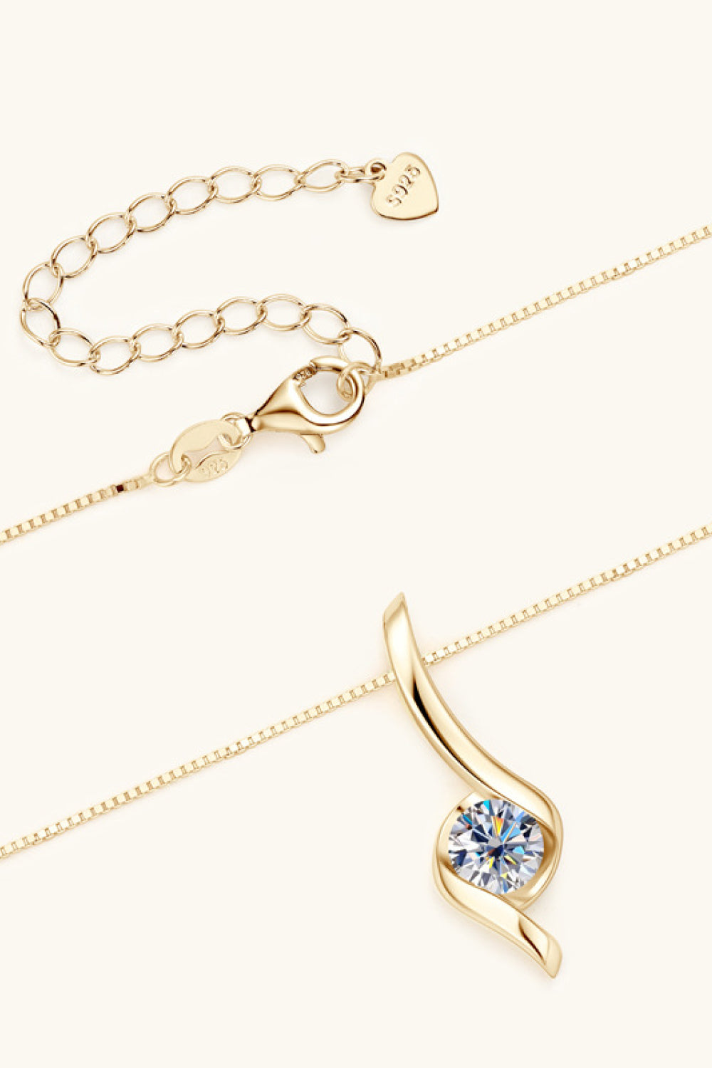 Gold necklace with a blue gemstone pendant on a white background