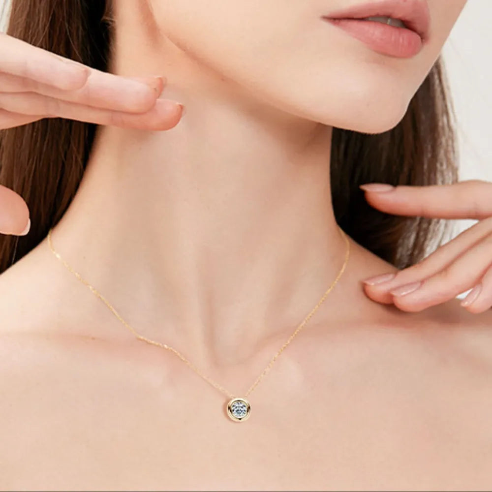 Gold necklace with a blue gemstone pendant on a model's neck