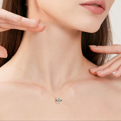 Gold necklace with a blue gemstone pendant on a model's neck