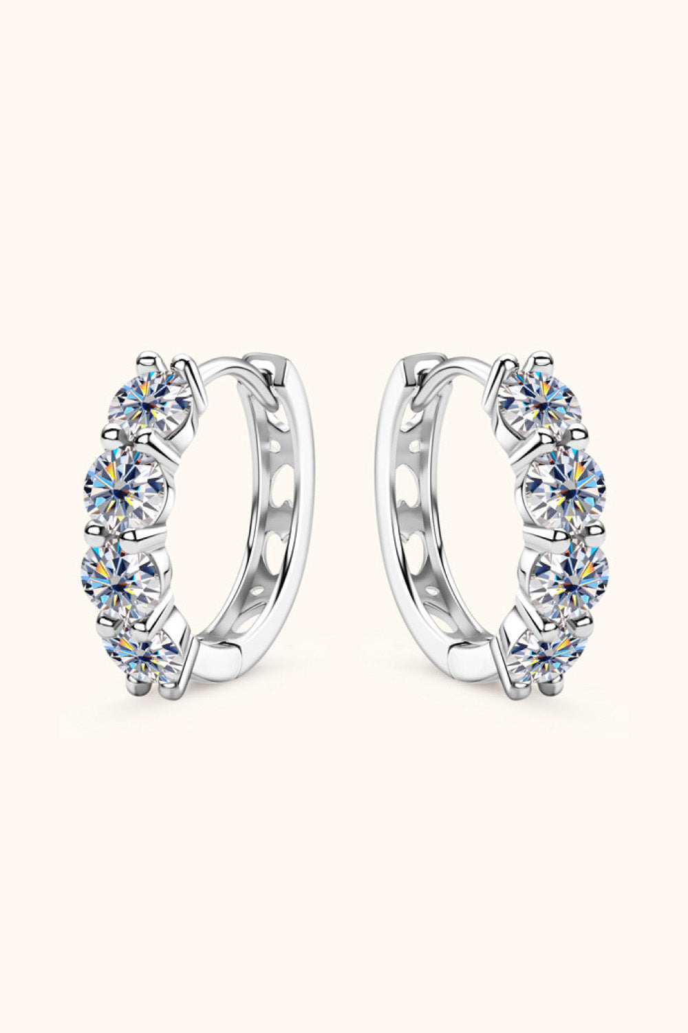Pair of silver hoop earrings with clear gemstones on a white background