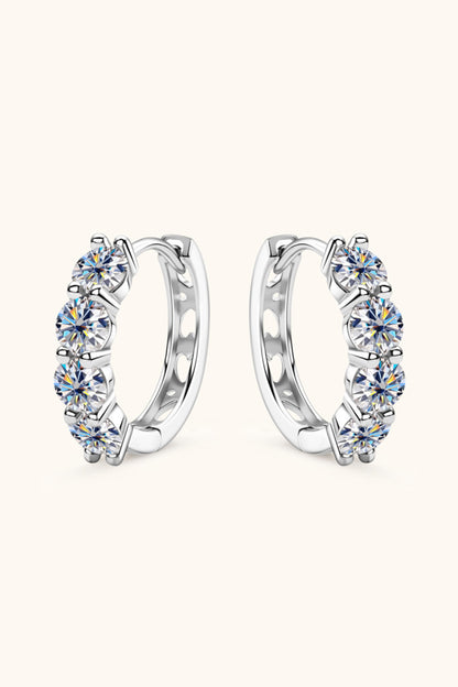 Pair of silver hoop earrings with clear gemstones on a white background