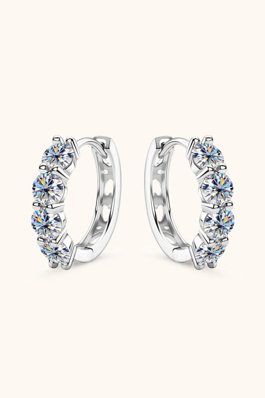 Pair of silver hoop earrings with clear gemstones on a white background