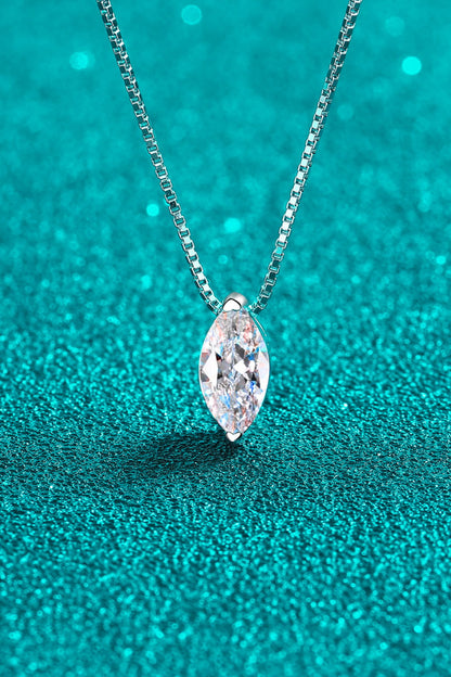 Silver necklace with a marquise-shaped diamond pendant on a teal glittery background
