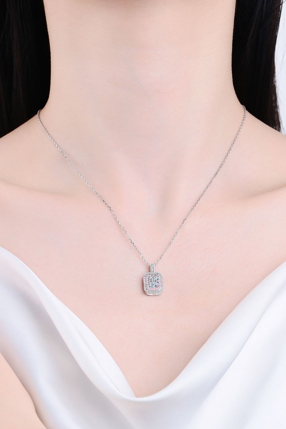 Silver necklace with a pendant on a person wearing a white top