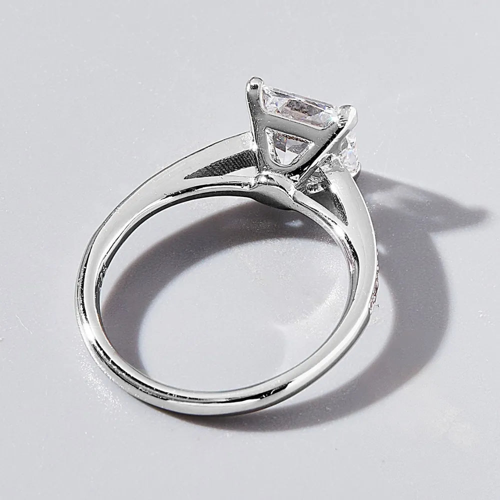 Silver ring with a diamond on a light gray background