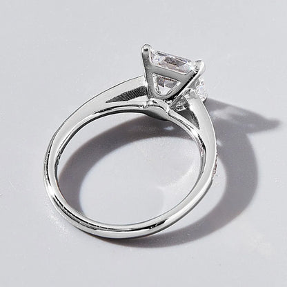 Silver ring with a diamond on a light gray background