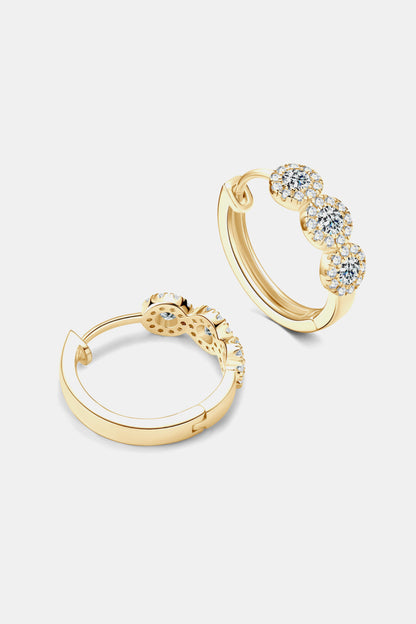 Gold hoop earrings with embedded stones on a light gray background