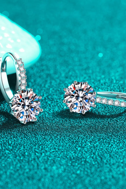 Diamond earrings on a teal glittery background