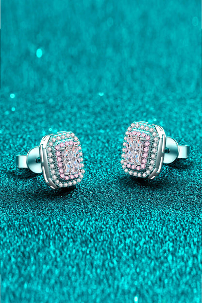 Pair of silver earrings with pink gemstones on a teal glittery background