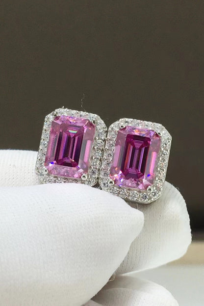 Pair of pink gemstone earrings on a white stand with a dark background