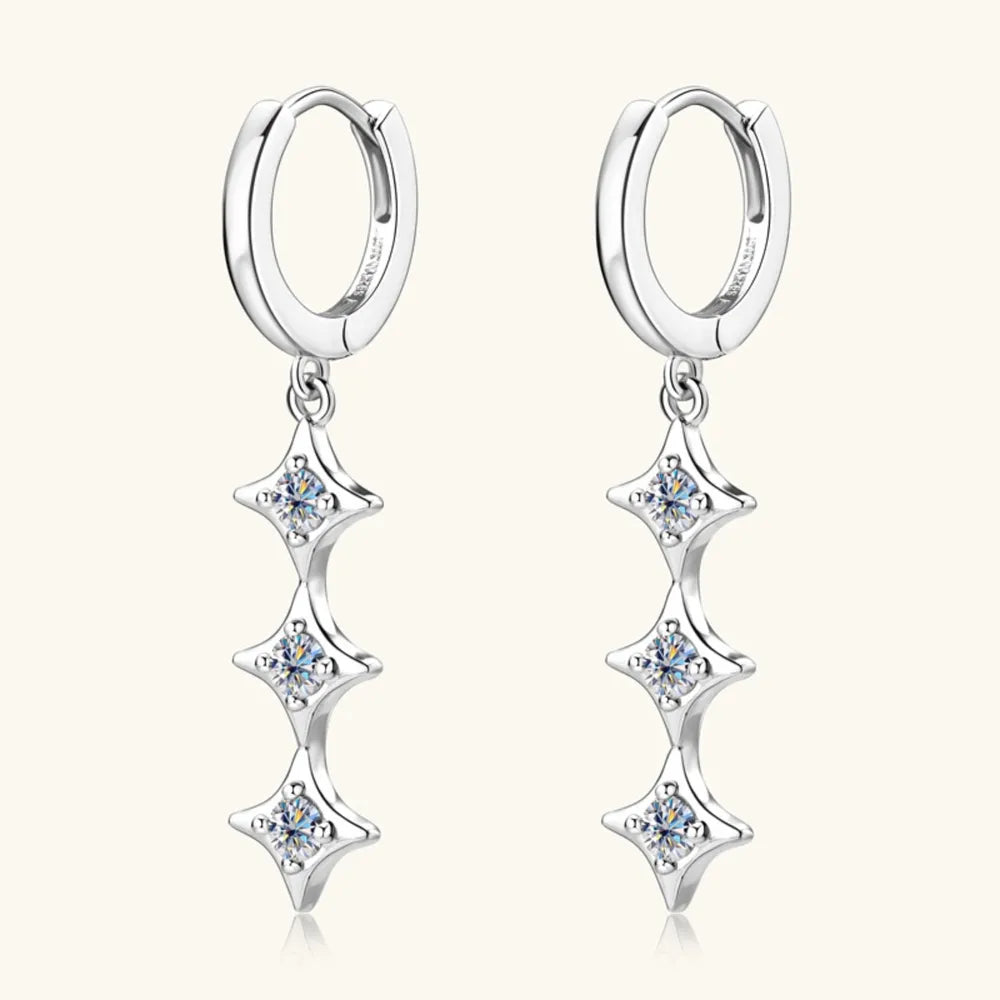 Silver hoop earrings with star-shaped dangling elements on a white background