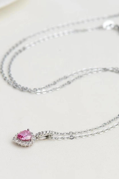 Silver necklace with a pink gemstone pendant on a light background
