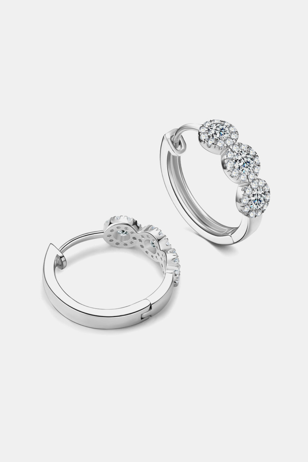 Pair of silver hoop earrings with clear gemstones on a light gray background