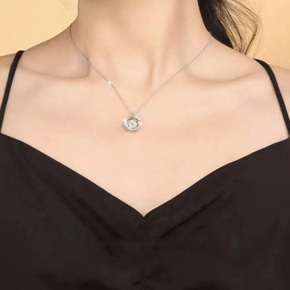 Necklace with a pendant worn by a person in a black top against a neutral background