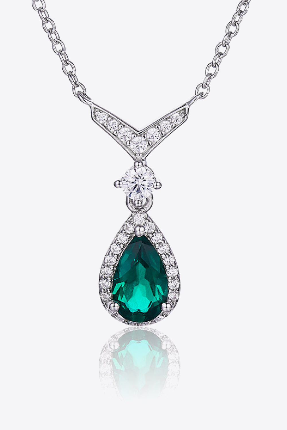 Emerald teardrop pendant with diamond accents on a white background