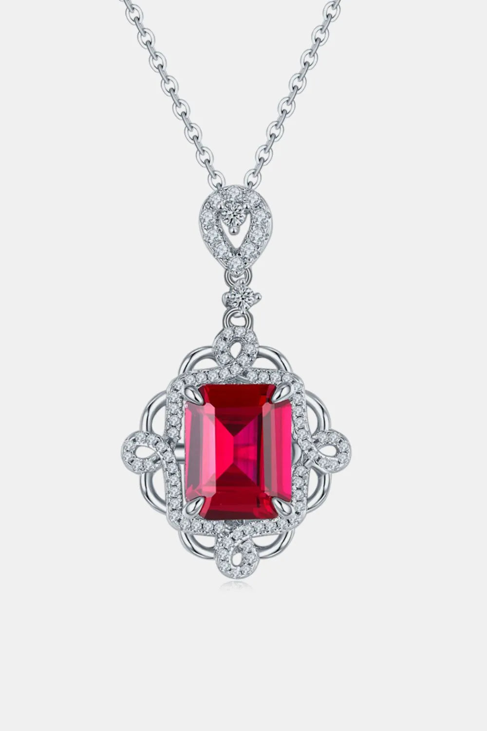 Elegant silver necklace with a red gemstone pendant on a white background