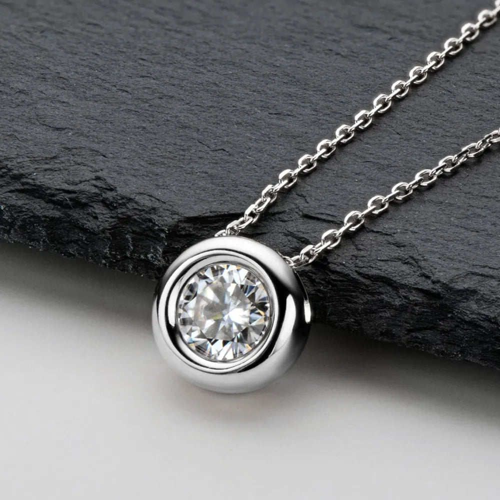Silver necklace with a diamond pendant on a dark stone surface