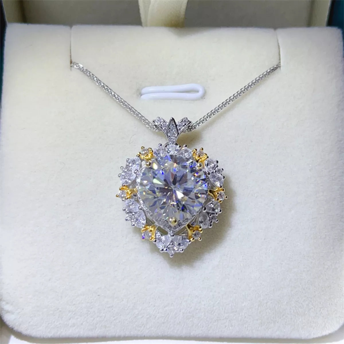 Diamond necklace with heart-shaped pendant on a white cushion