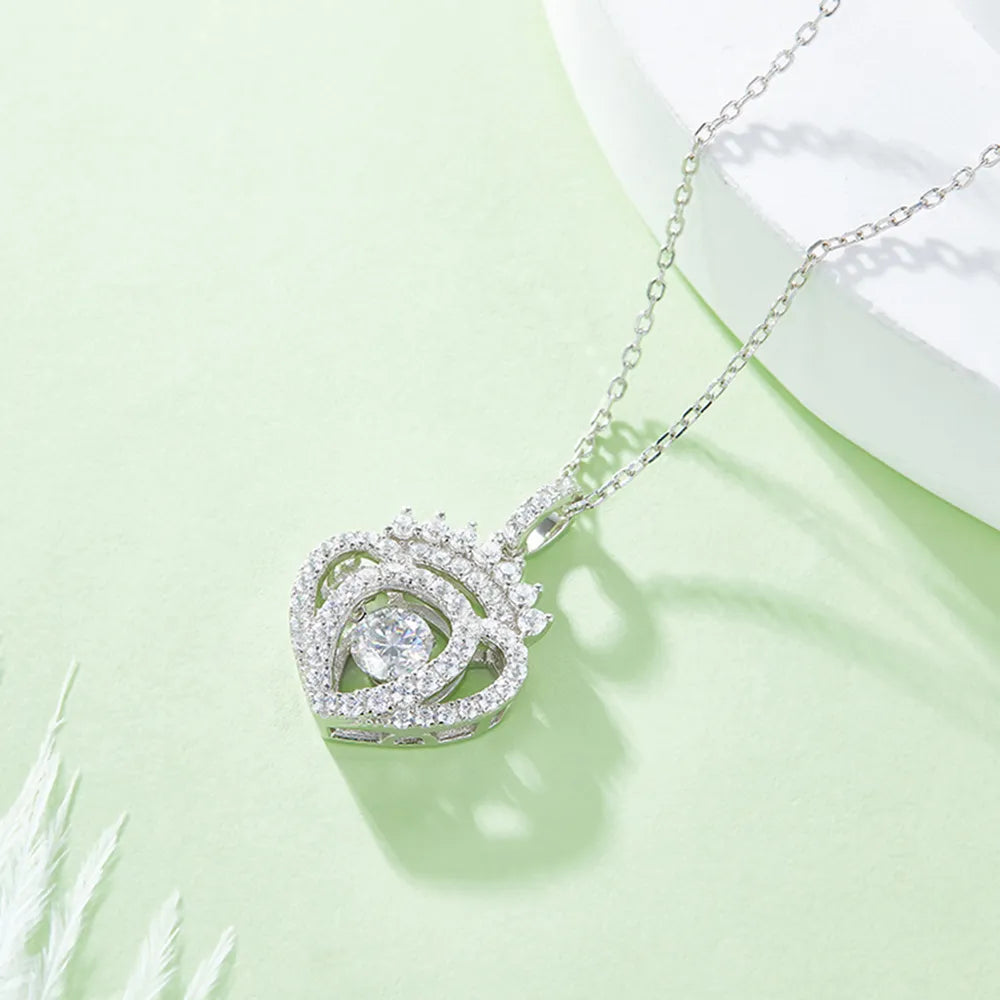Silver necklace with a heart-shaped pendant on a light green background