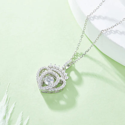 Silver necklace with a heart-shaped pendant on a light green background