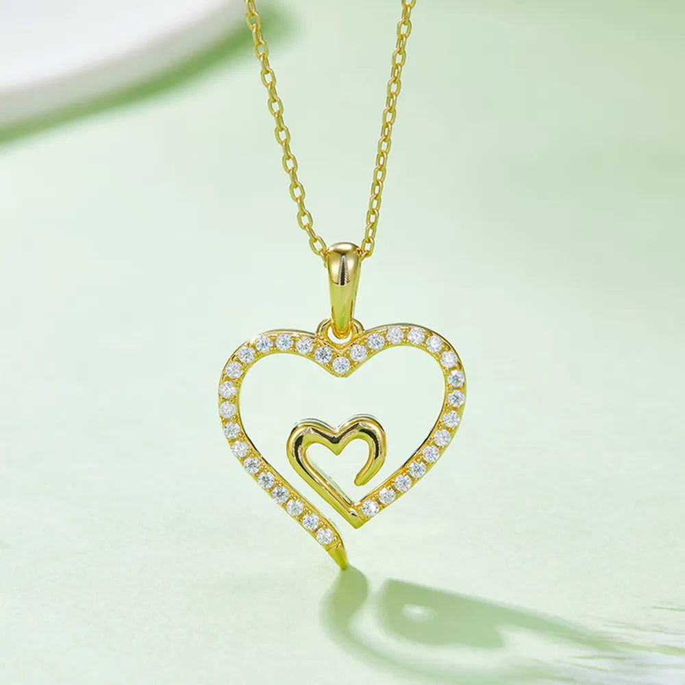 Gold heart-shaped pendant necklace on a light green background