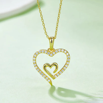 Gold heart-shaped pendant necklace on a light green background