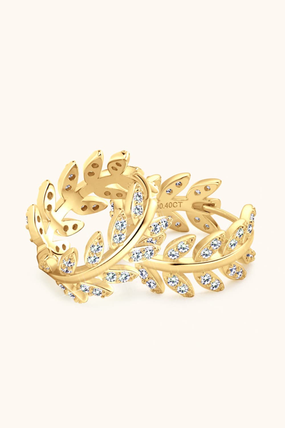Gold ring with intricate design and small diamonds on a white background