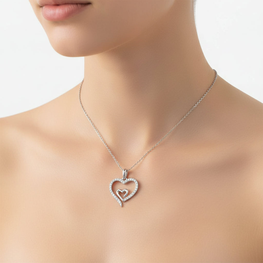Silver heart-shaped necklace on a mannequin with a plain background