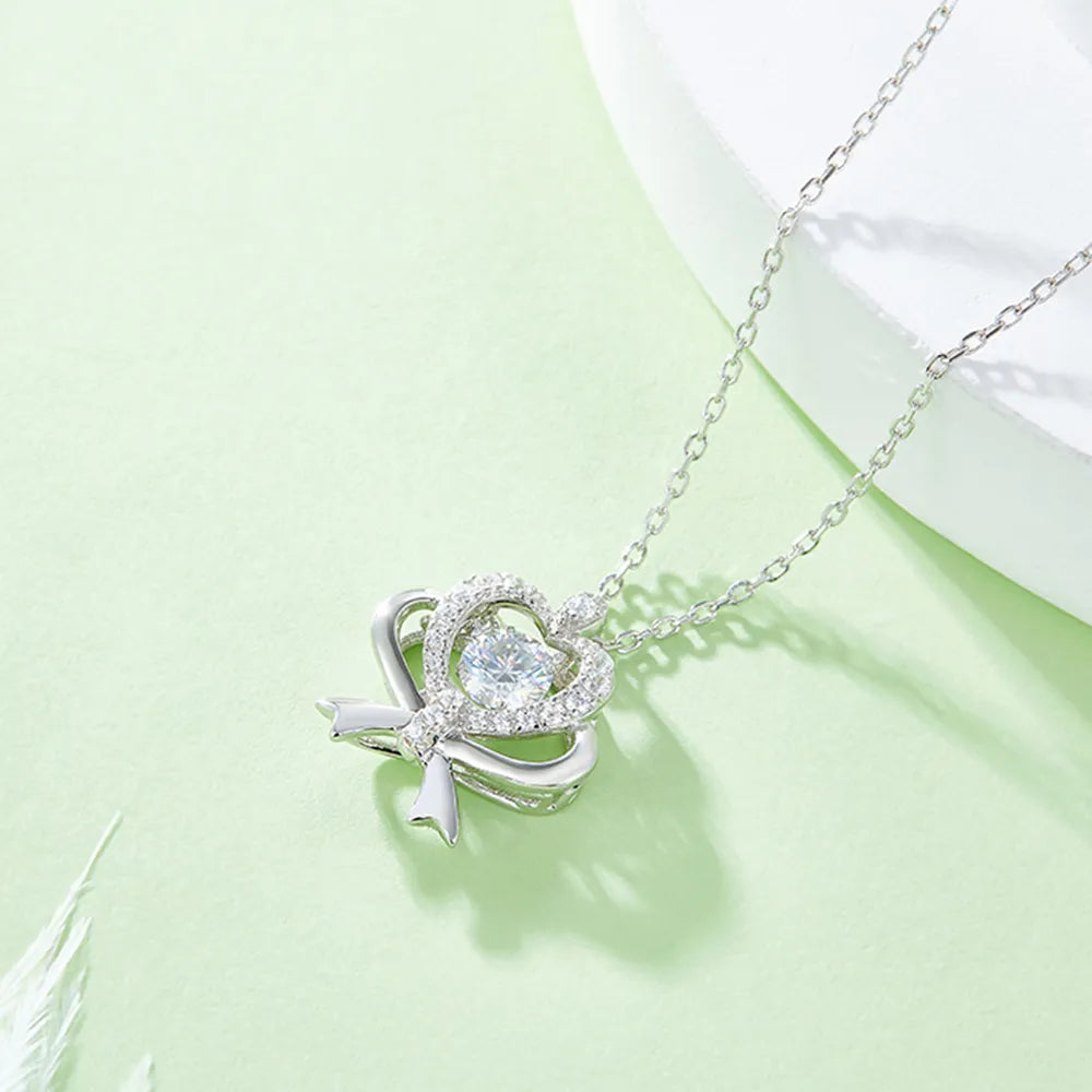 Silver necklace with a heart-shaped pendant on a light green background