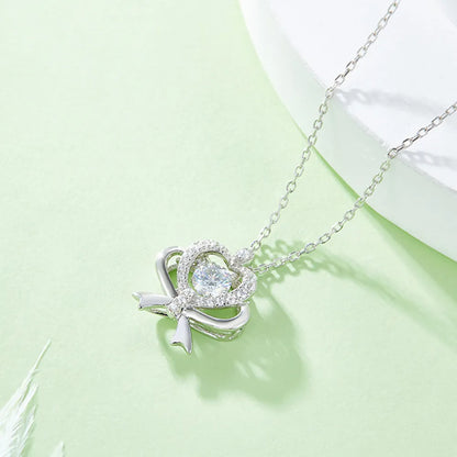 Silver necklace with a heart-shaped pendant on a light green background