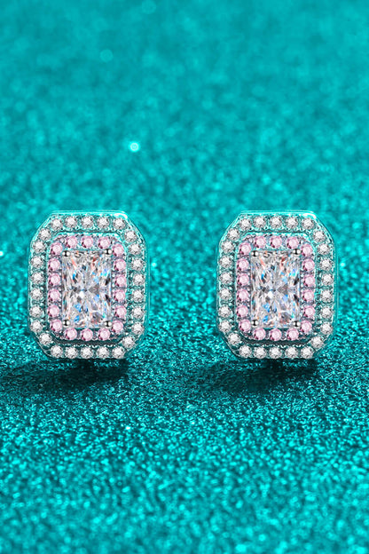 Pair of diamond earrings on a teal glittery background