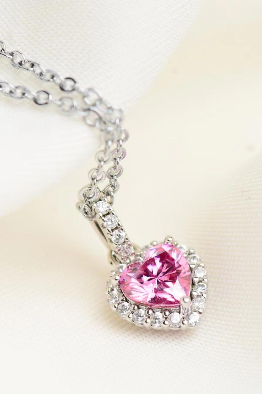 Necklace with a pink heart-shaped gemstone pendant on a light background