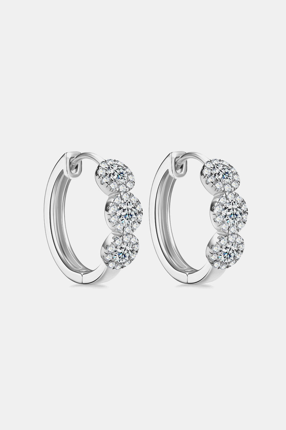 Pair of silver hoop earrings with clear gemstones on a light gray background