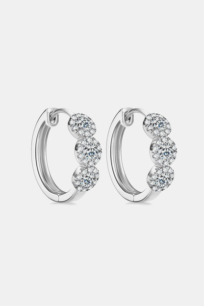 Pair of silver hoop earrings with clear gemstones on a light gray background
