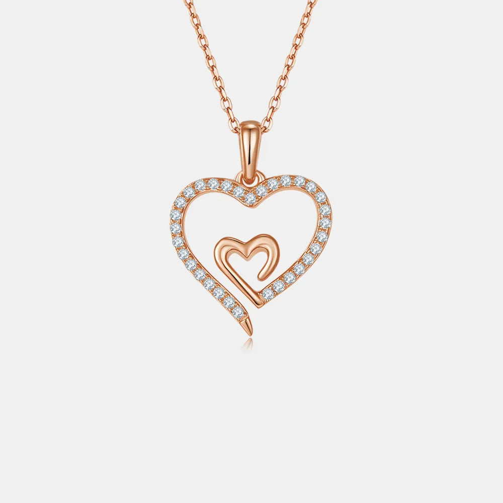 Rose gold heart-shaped necklace with small diamonds on a light gray background