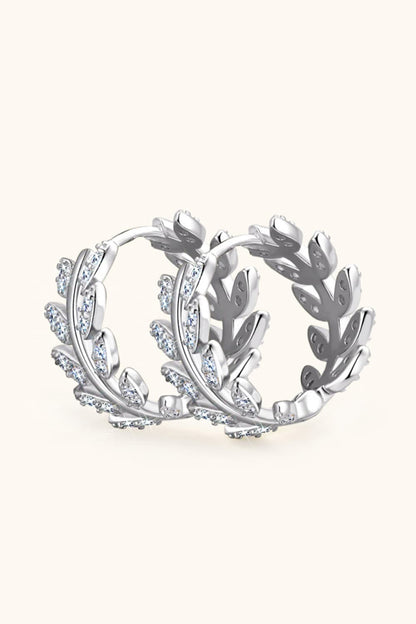 Silver hoop earrings with leaf design on a white background