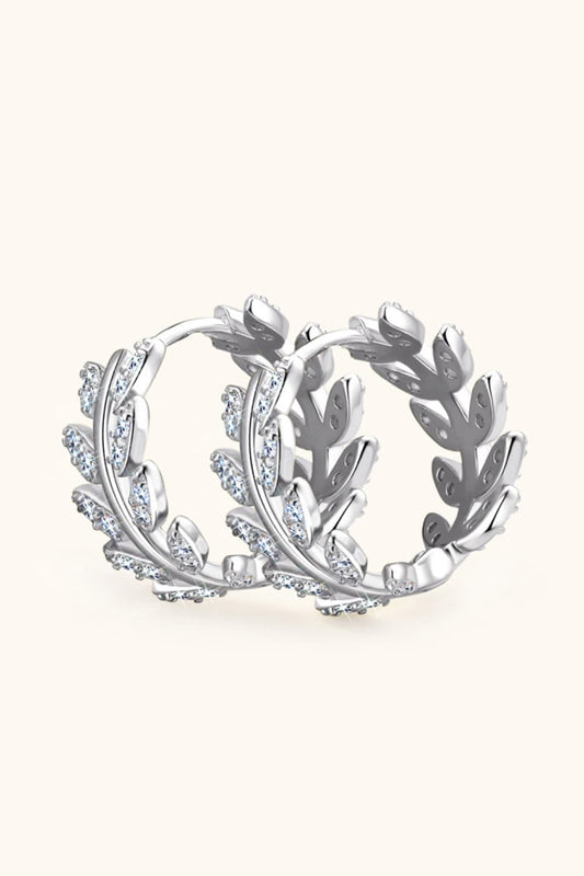 Silver hoop earrings with leaf design on a white background