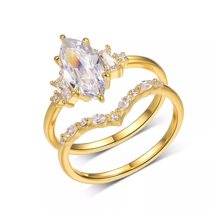 Gold ring with clear gemstones on a white background