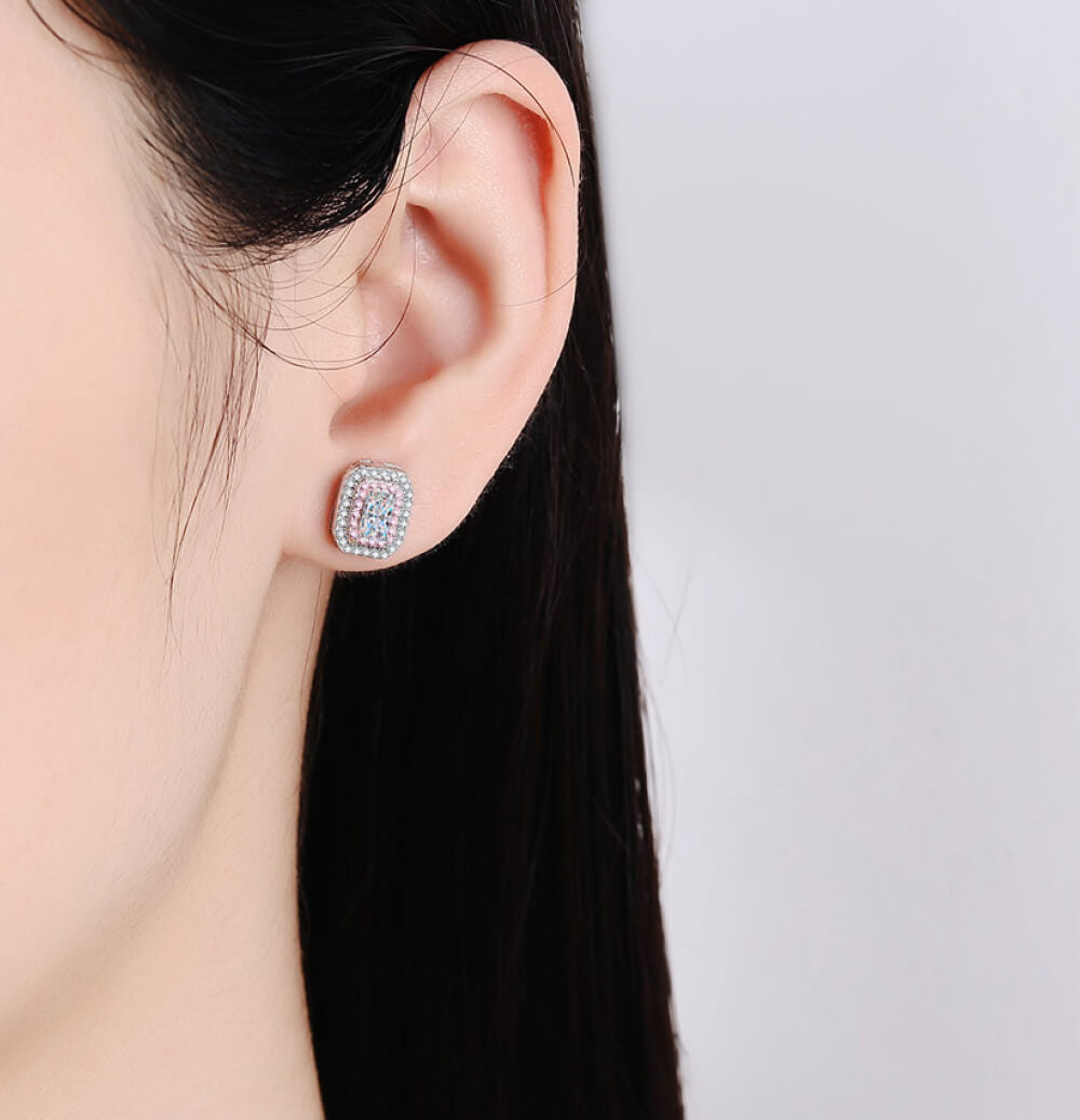 Earring worn by a person on a plain background