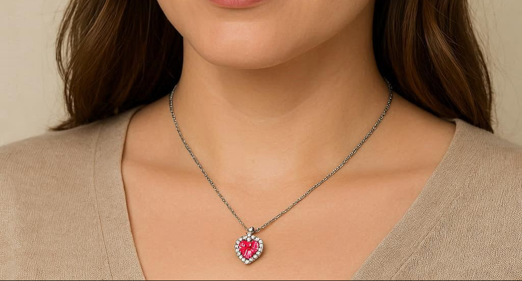 Necklace with a heart-shaped pink pendant worn by a person