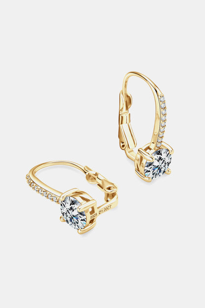 Gold hoop earrings with clear gemstones on a light gray background