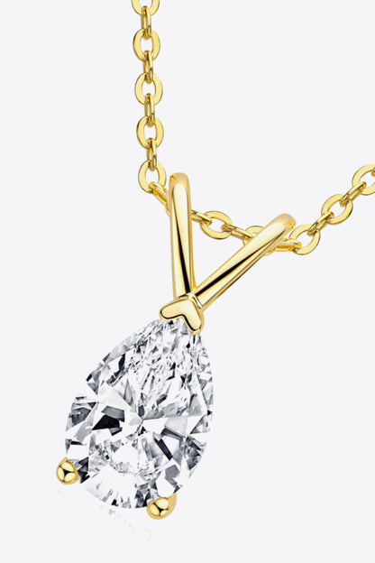Gold necklace with a teardrop-shaped diamond pendant on a white background